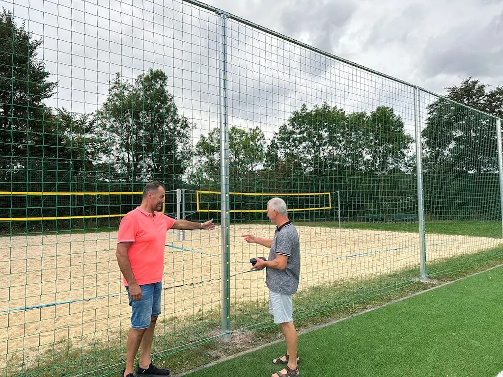Der Vereinsvorsitzende der Sportgemeinschaft Wurgwitz e.V. und der Abteilungsleiter Volleyball stehen vor dem neu errichteten Ballfangnetz, das in dieser Kalenderwoche fertiggestellt wurde.